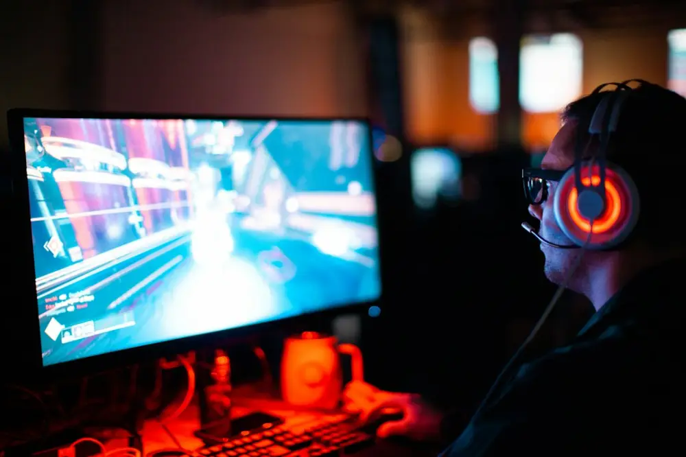 Person using computer playing FPS game, illustrating understanding competitive gaming performance metrics